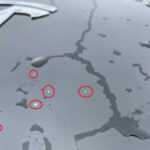 Detaljbild på lacksläpp på en Tesla.