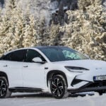 BYD SEALION 7 fotad snett framifrån med snöig skog i bakgrunden.