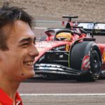 Dino Beganovic, leende i Ferraris teamkläder, med en Ferrari F1-bil i bakgrunden under tester på banan.