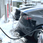Flera Tesla-bilar står och laddar vid Tesla-laddare.