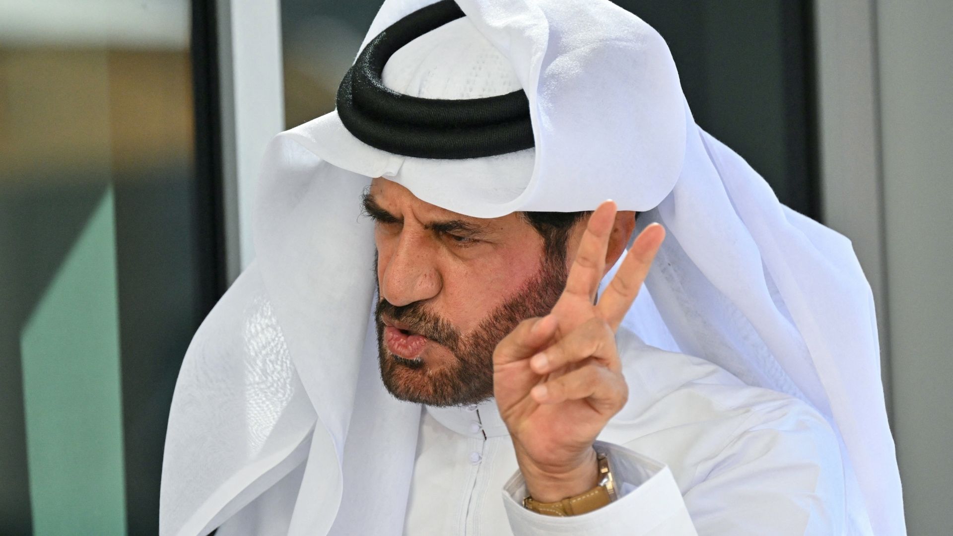 Mohammed Ben Sulayem, FIA:s president, gestikulerar under ett samtal under en F1-helg. Han är klädd i traditionell vit arabisk dräkt och visar ett intensivt uttryck.