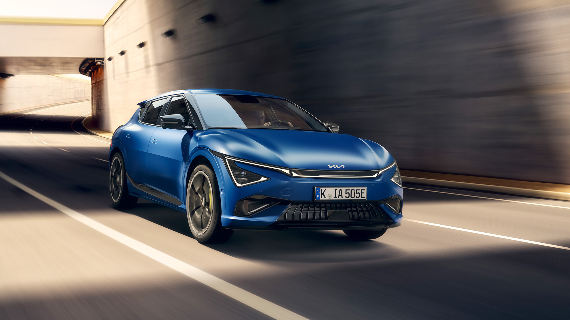 Blå Kia EV6 GT framifrån körandes på väg.
