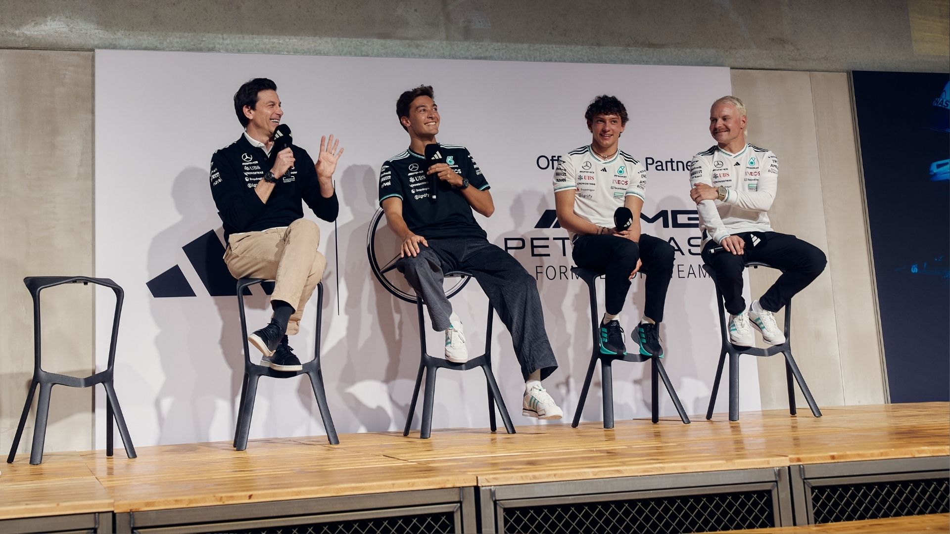 Toto Wolff, George Russell, Kimi Antonelli och Valtteri Bottas sitter på scen under Mercedes och Adidas lansering, klädda i det nya teamkitet.