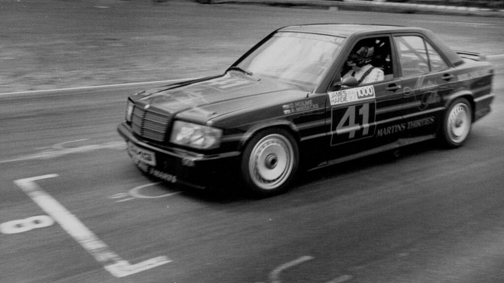 Svartvit bild på en Mercedes-Benz 190E, här i DTM-utförande körd av Denny Hulme. 
