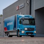 En blå eldriven lastbil från PostNord, en Mercedes-Benz eActros, parkerad framför Veho Bil i Västerås. Symbol för PostNords satsning på hållbara leveranser.