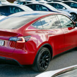 Röd Tesla Model Y snett bakifrån