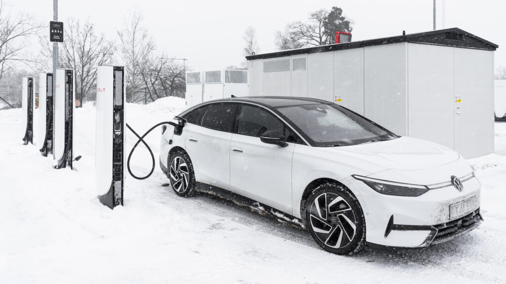 Vit Volkswagen ID. 7 Pro laddar vid Tesla Supercharger 4 om vintern.