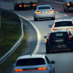Volvo V60 kör med släcka bakljus i skymningen på motorväg.