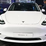 Frontalvy av en vit Tesla Model Y från den ursprungliga designen 2020. Rykten pekar på en större uppdatering till 2025 som ska modernisera modellen.