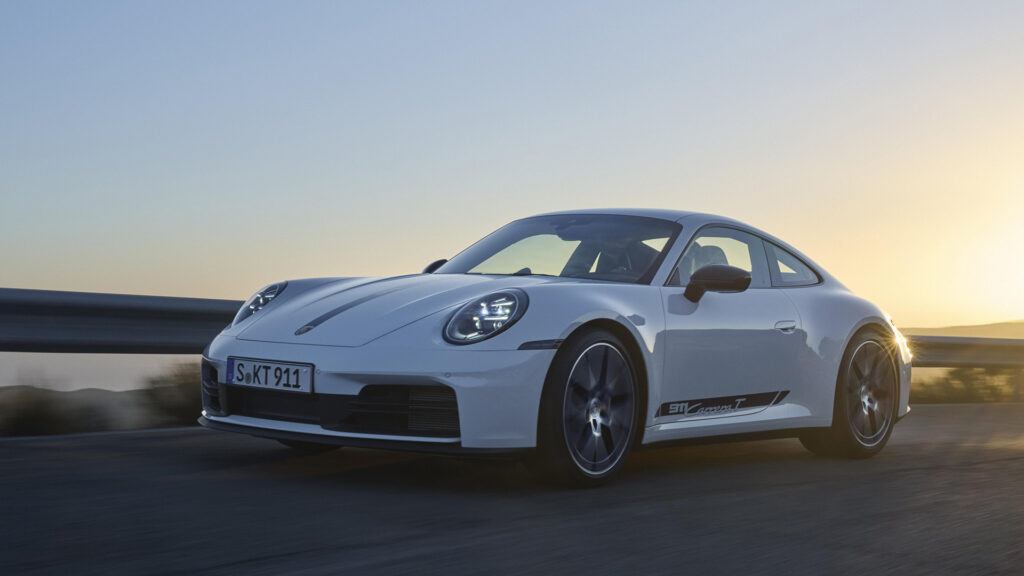 Bild på en vit 911 T med solnedgång i bakgrunden.