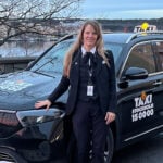 Taxiföraren Sofia Göransson står framför sin Mercedes-Benz-taxi.