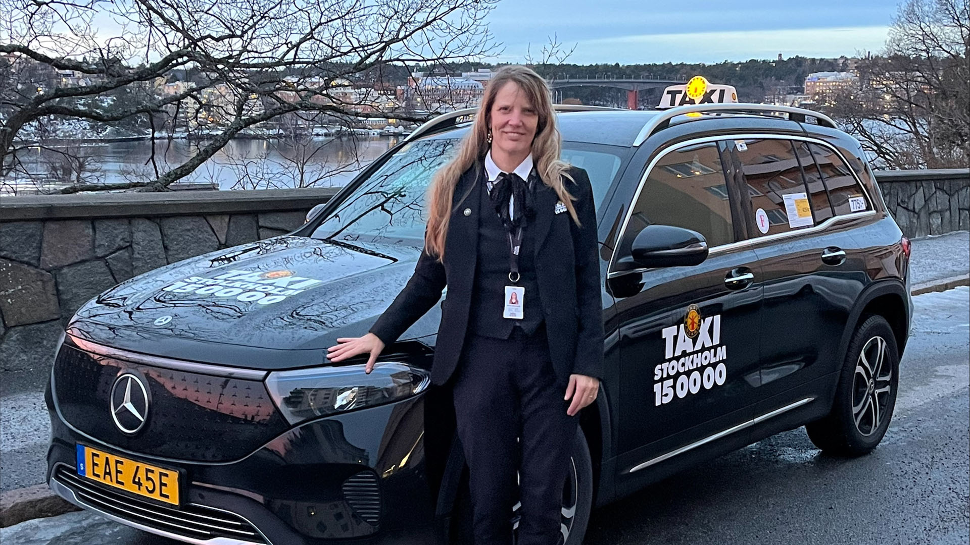 Taxiföraren Sofia Göransson står framför sin Mercedes-Benz-taxi.