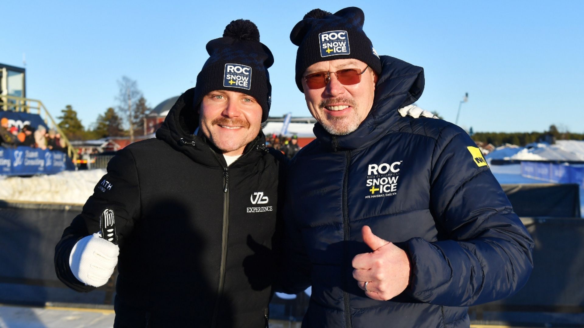 Valtteri Bottas och Mika Häkkinen poserar i vinterkläder under Race of Champions Snow + Ice i Piteå. Häkkinen ersätts av Heikki Kovalainen inför ROC 2025 i Sydney.